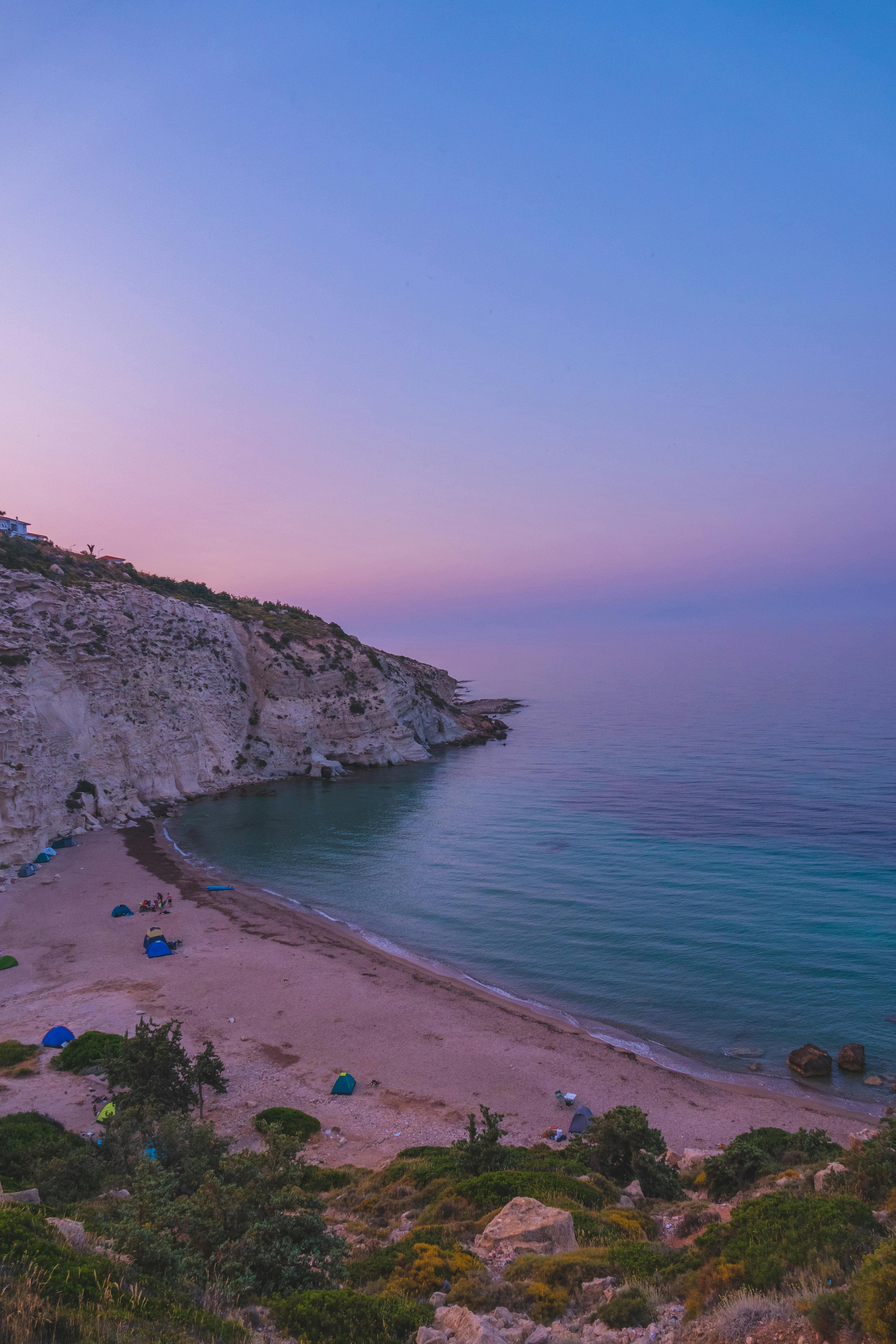 Beautiful pink sunrise over the tranquil coast of İzmir, Türkiye, with a serene beach view.