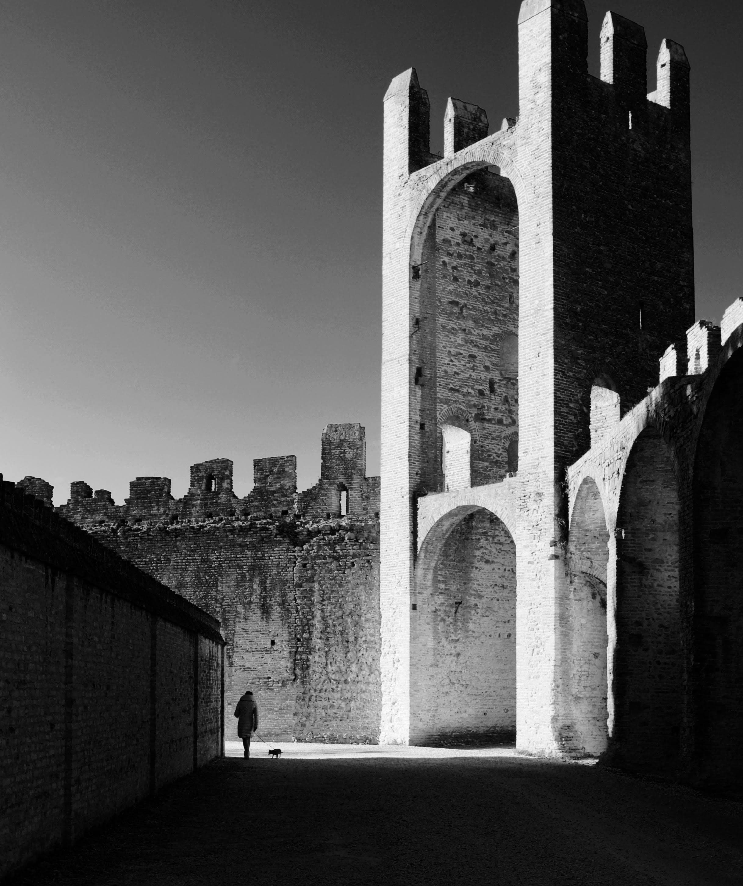 Dramatic black and white photo of a person in an ancient fortress.