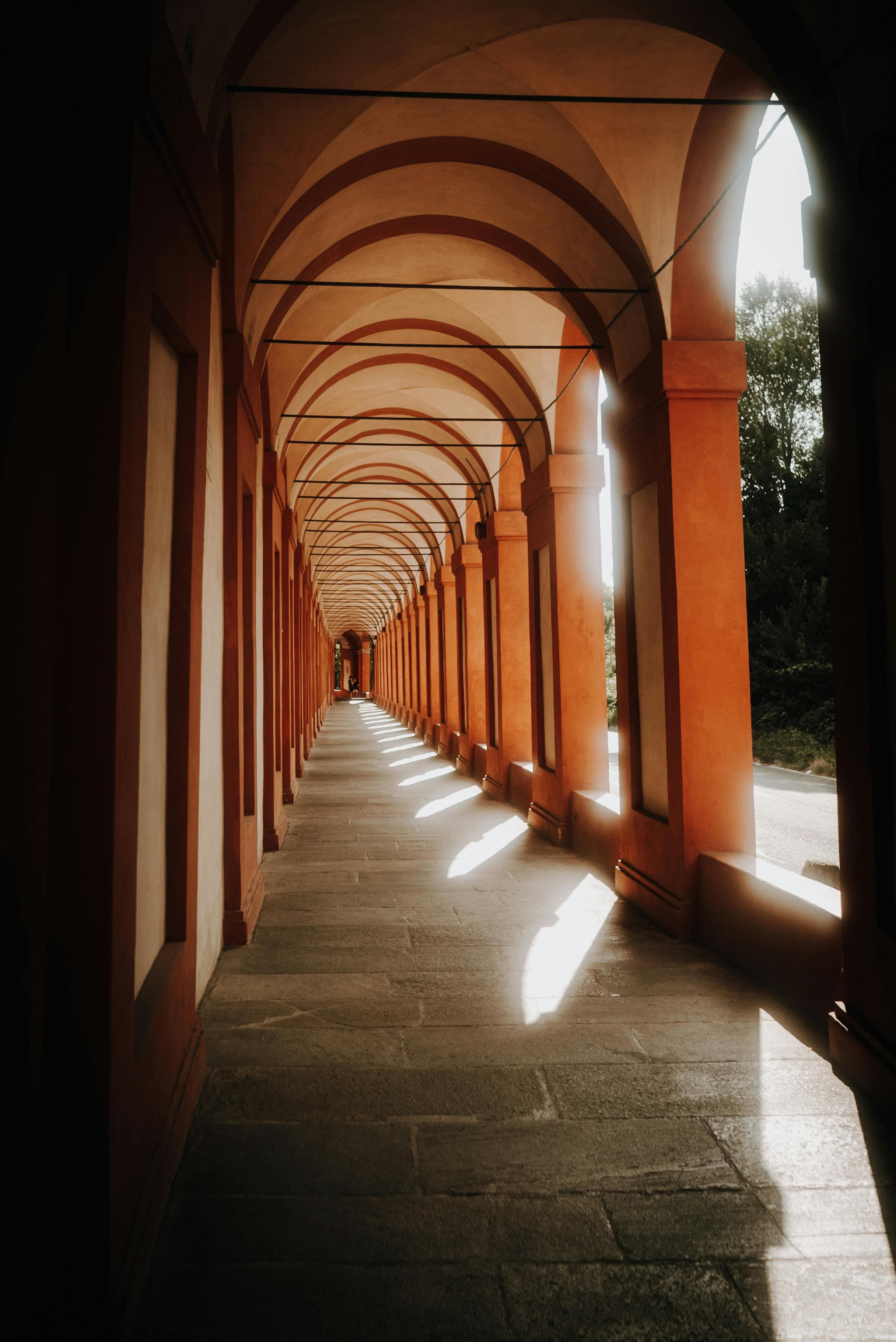 Explore the captivating sunlit corridors of an Italian portico, showcasing timeless architecture.