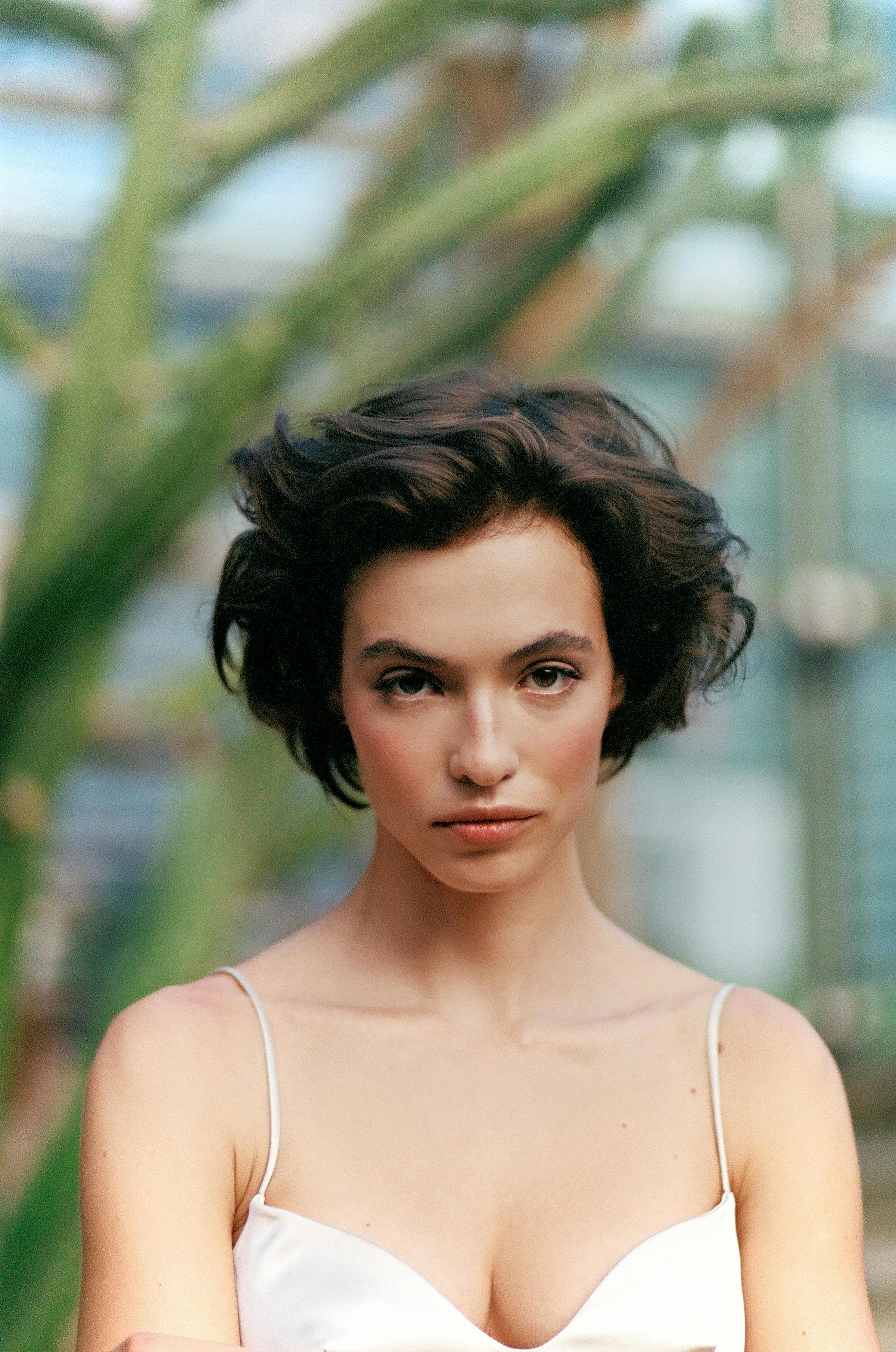 Portrait of a woman with stylish short hair in a natural setting, showcasing fashion and elegance.