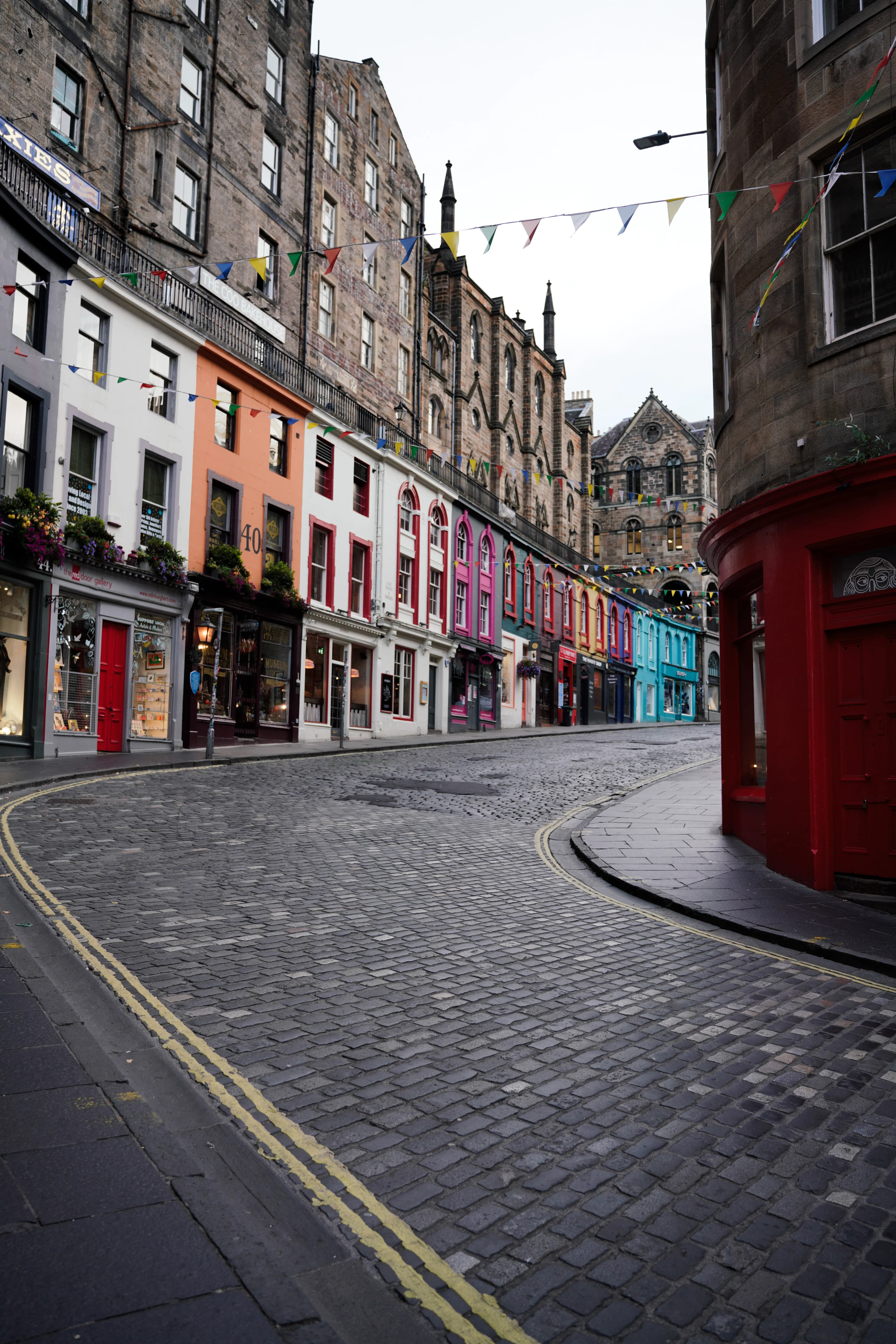 Charming view of Victoria Street with colorful buildings and cobblestones in Edinburgh, Scotland.