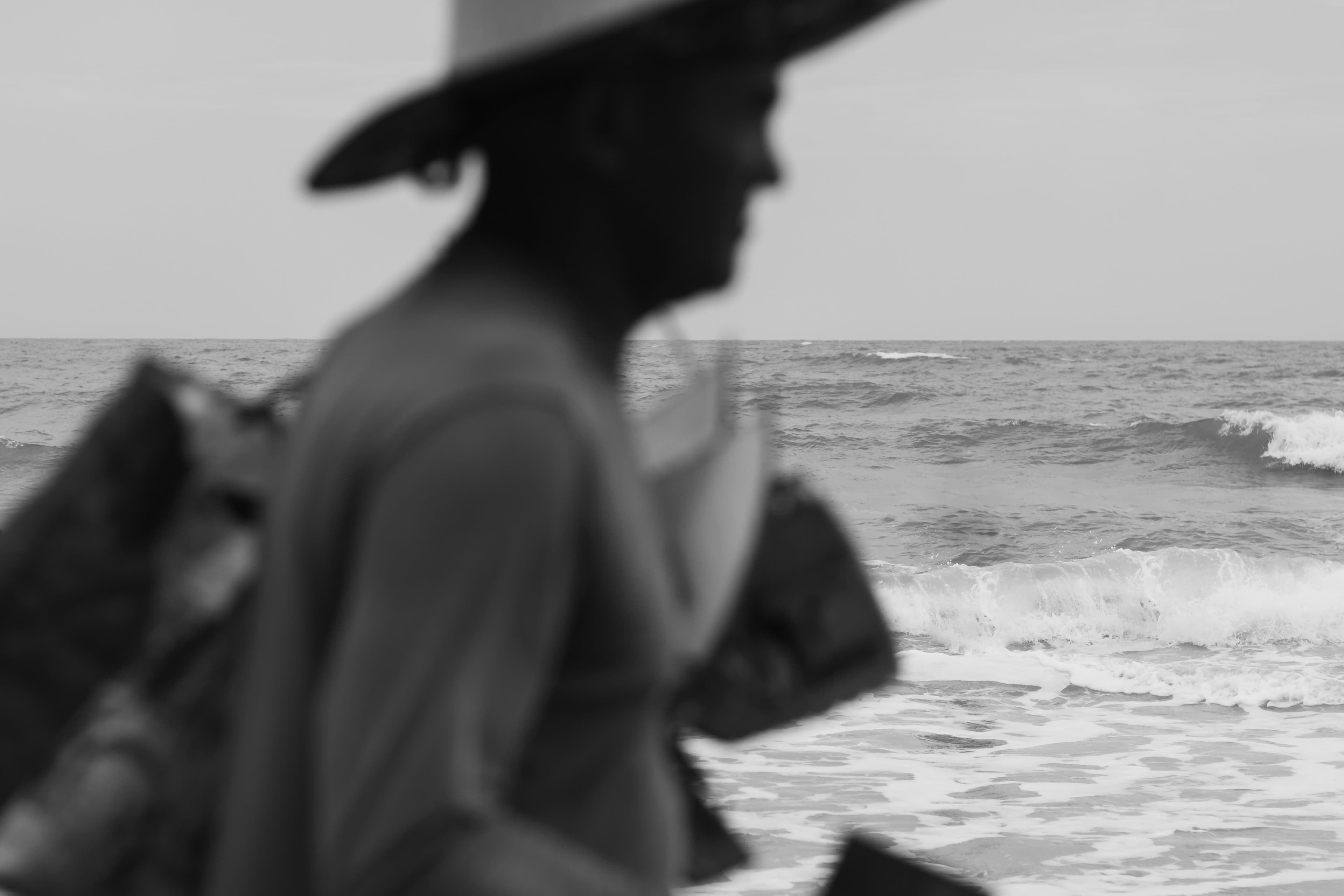 Black and white silhouette of a beach vendor with the ocean backdrop at Canoa Quebrada, Brazil.