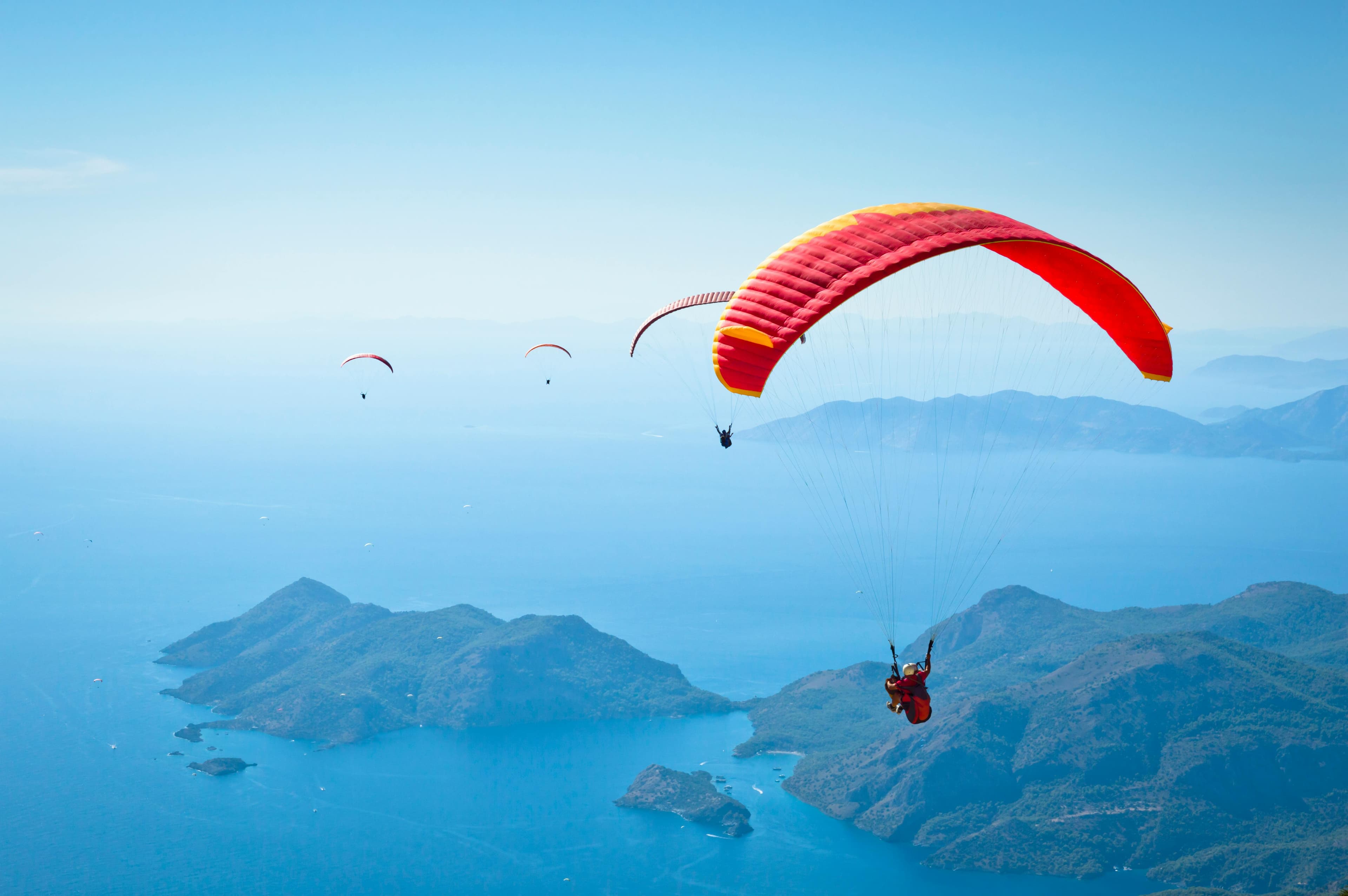 Experience stunning views while paragliding high above the beautiful blue waters of Ölüdeniz, Turkey.