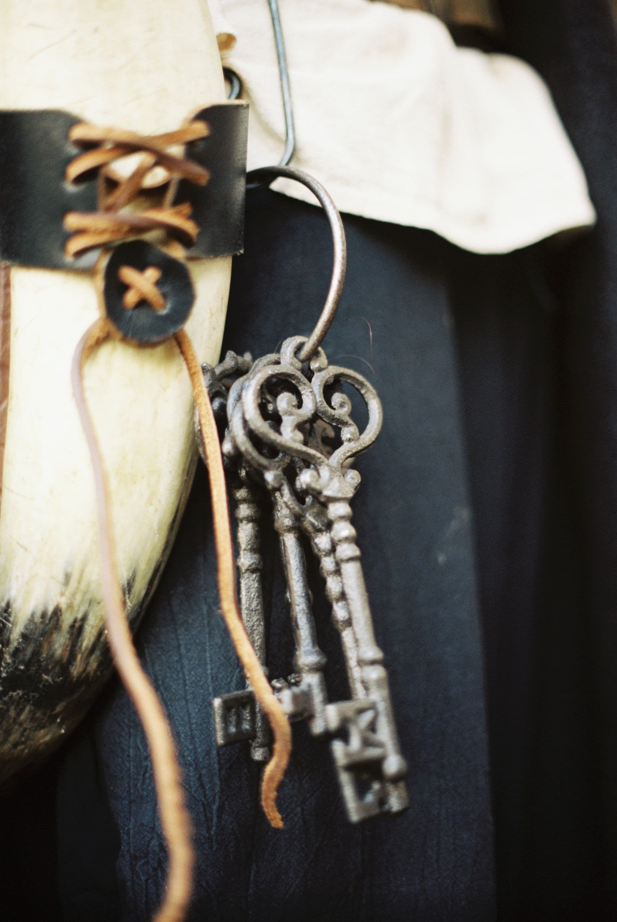 Close-up of vintage iron keys attached to a leather-clad horn.
