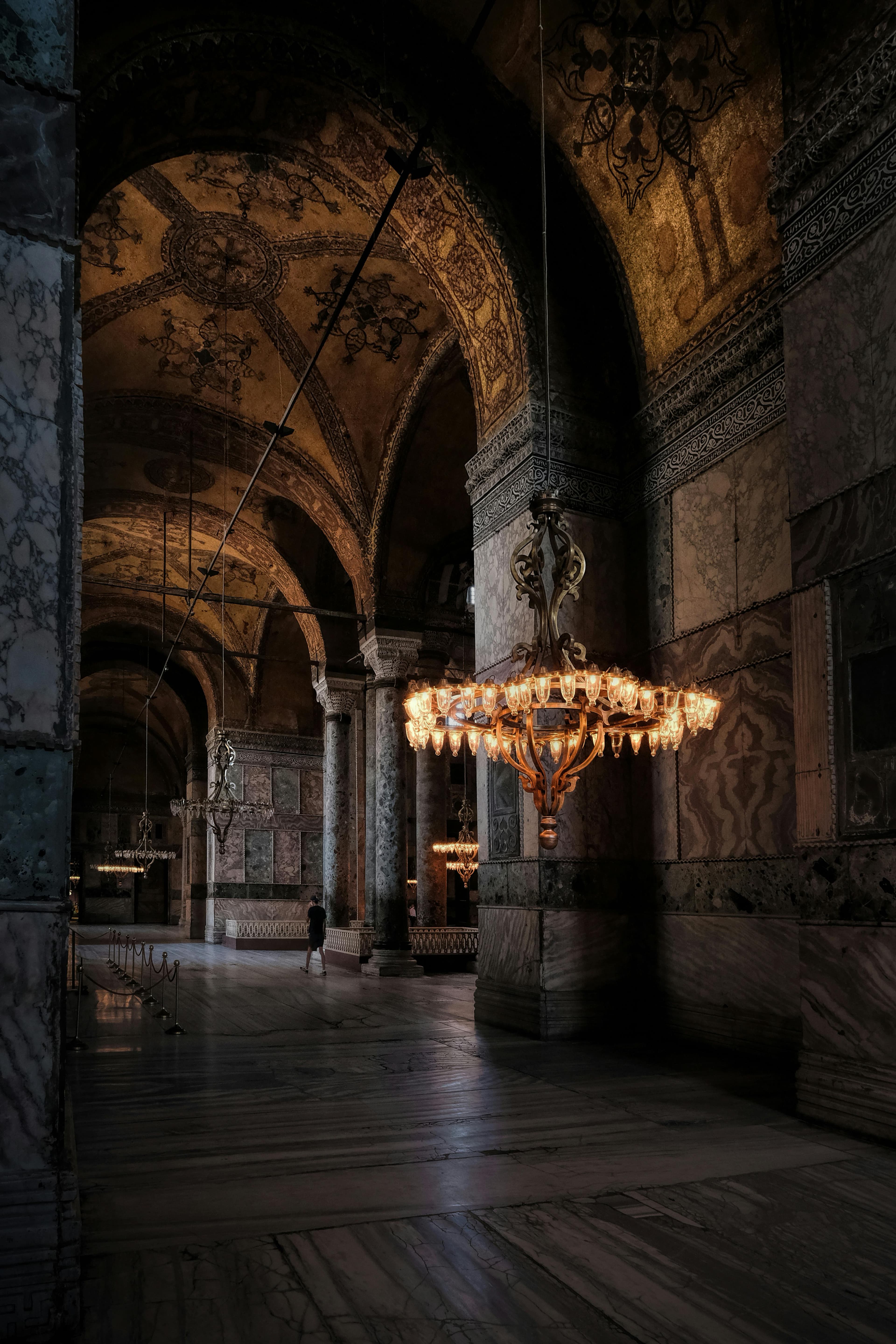 Captivating view of the ornate interiors of Hagia Sophia, featuring majestic arches and chandeliers.