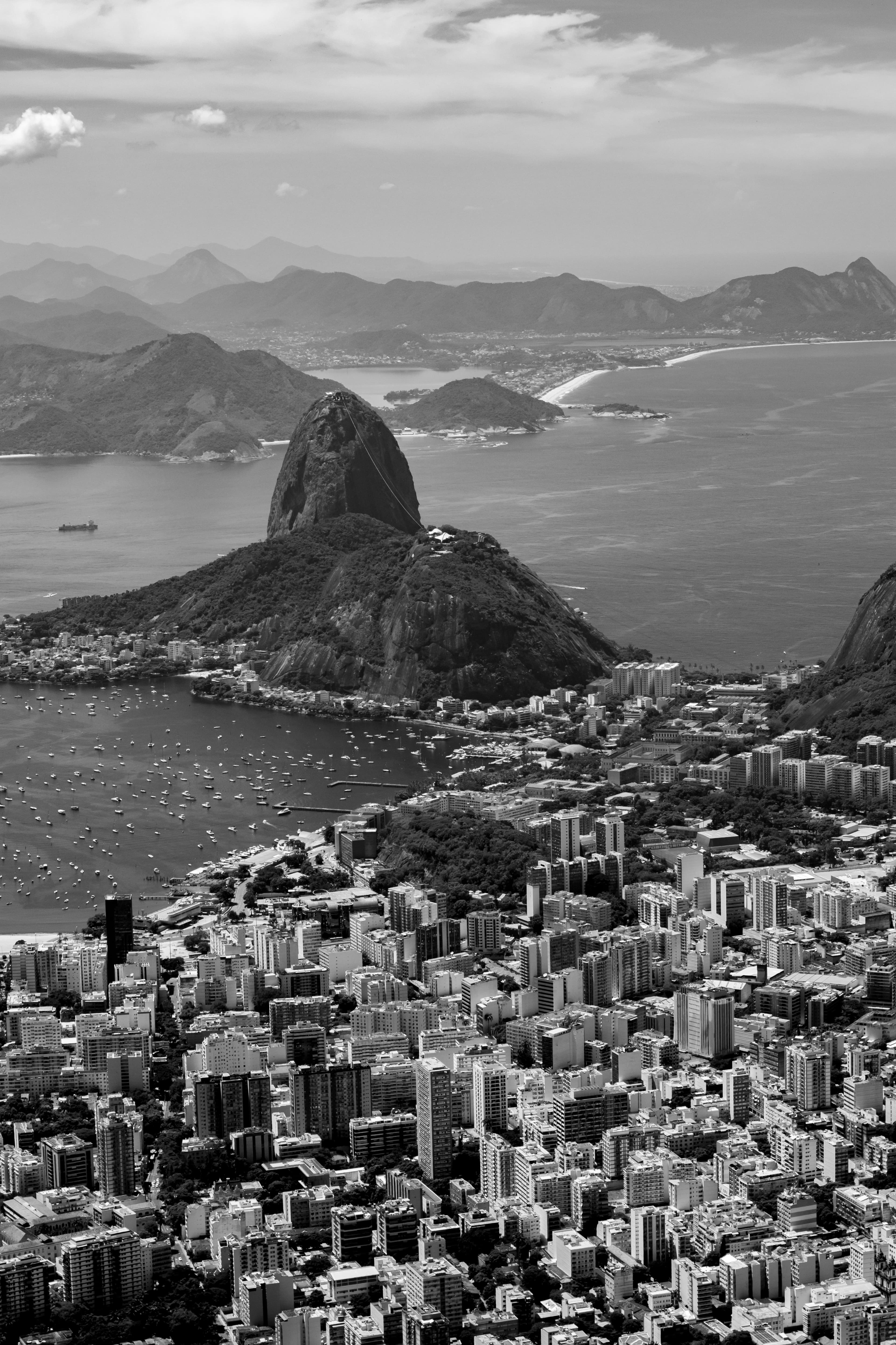 Black and white aerial photo of Rio de Janeiro with iconic Sugarloaf Mountain and coastline.